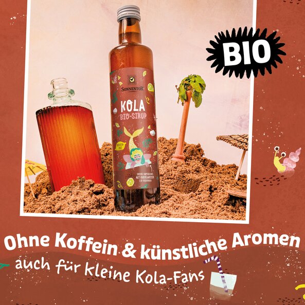 Cola syrup bottle in beach scene with drink, palm tree and text “ORGANIC” and “without caffeine & artificial flavors also for young cola fans” | © SONNENTOR